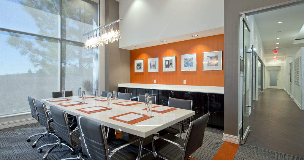 Modern hotel boardroom with orange accent wall